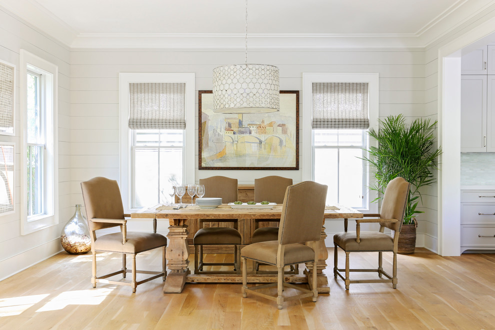 Inspiration for a beach style enclosed dining room in Charleston with white walls, medium hardwood flooring and brown floors.