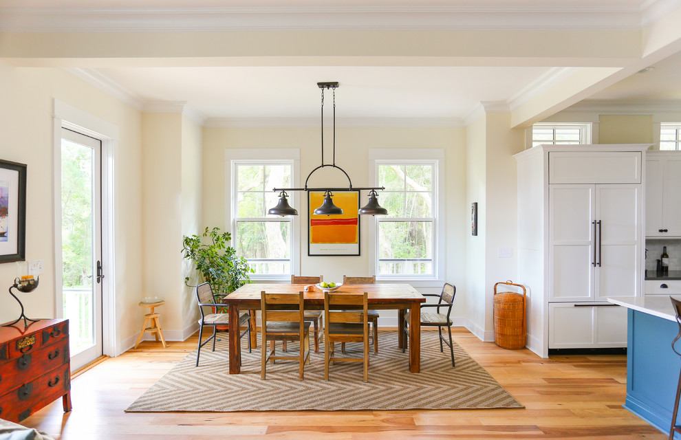 Foto di una sala da pranzo aperta verso la cucina chic con pareti beige e parquet chiaro