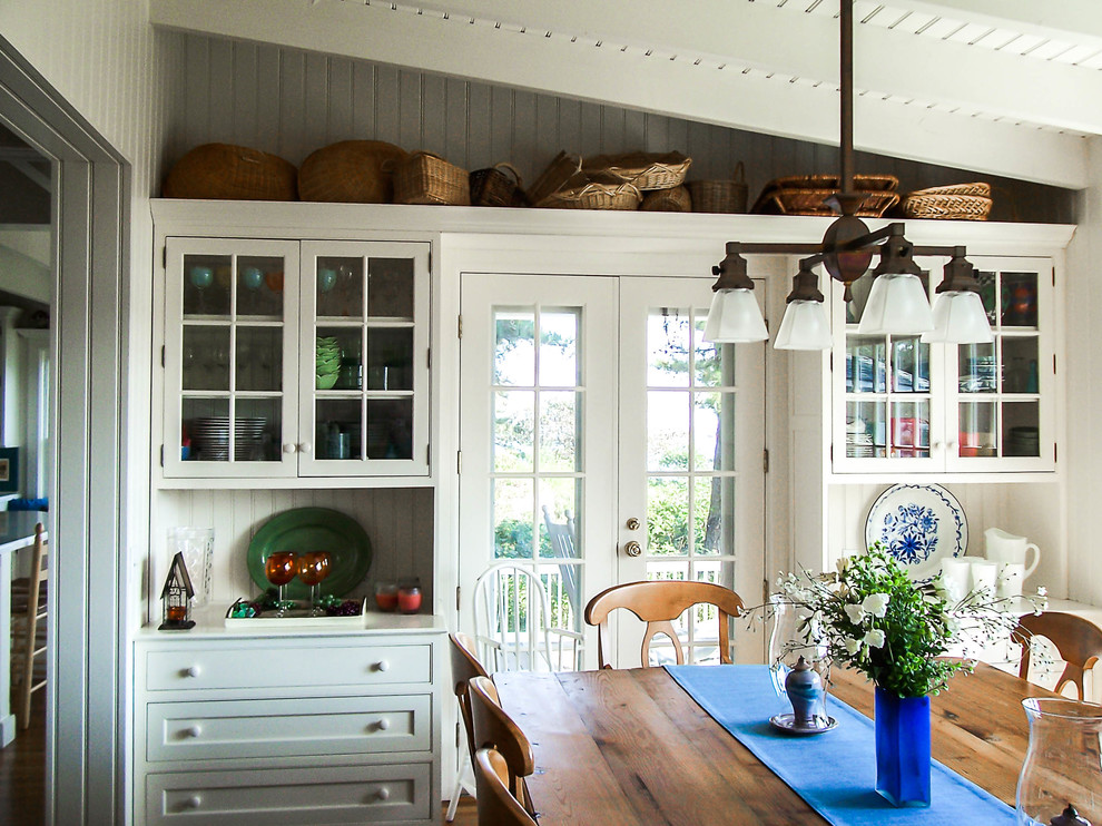 Imagen de comedor de estilo de casa de campo de tamaño medio cerrado con suelo de madera en tonos medios y paredes blancas
