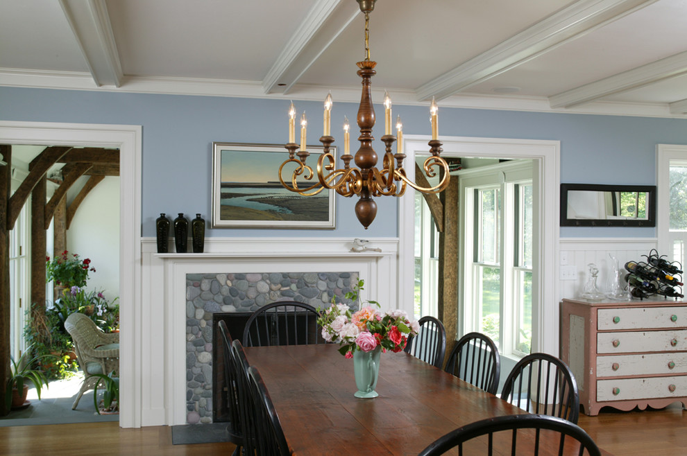 Example of a mid-sized classic medium tone wood floor enclosed dining room design in Boston with blue walls, a standard fireplace and a stone fireplace