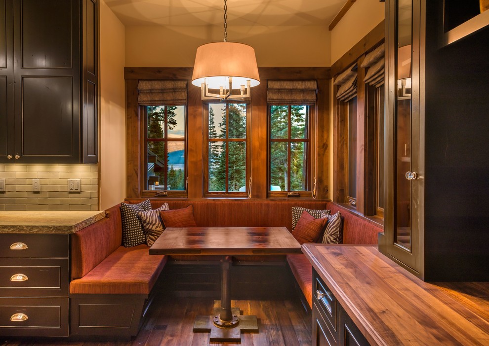 Idée de décoration pour une salle à manger ouverte sur la cuisine chalet avec un sol en bois brun.