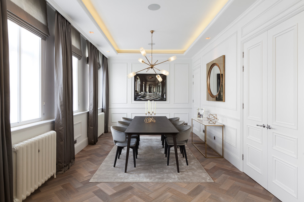Design ideas for a medium sized traditional enclosed dining room in London with white walls and medium hardwood flooring.