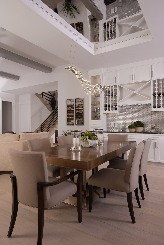 Ispirazione per una sala da pranzo aperta verso il soggiorno tradizionale con pareti bianche e parquet chiaro