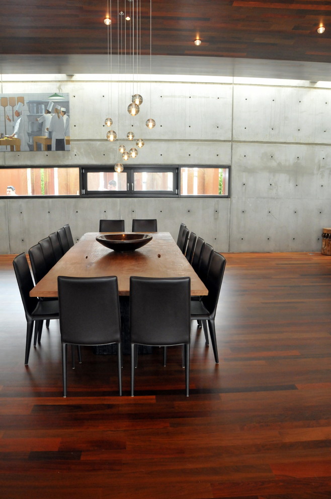 Idée de décoration pour une grande salle à manger ouverte sur le salon urbaine avec un mur gris, parquet foncé et un sol marron.