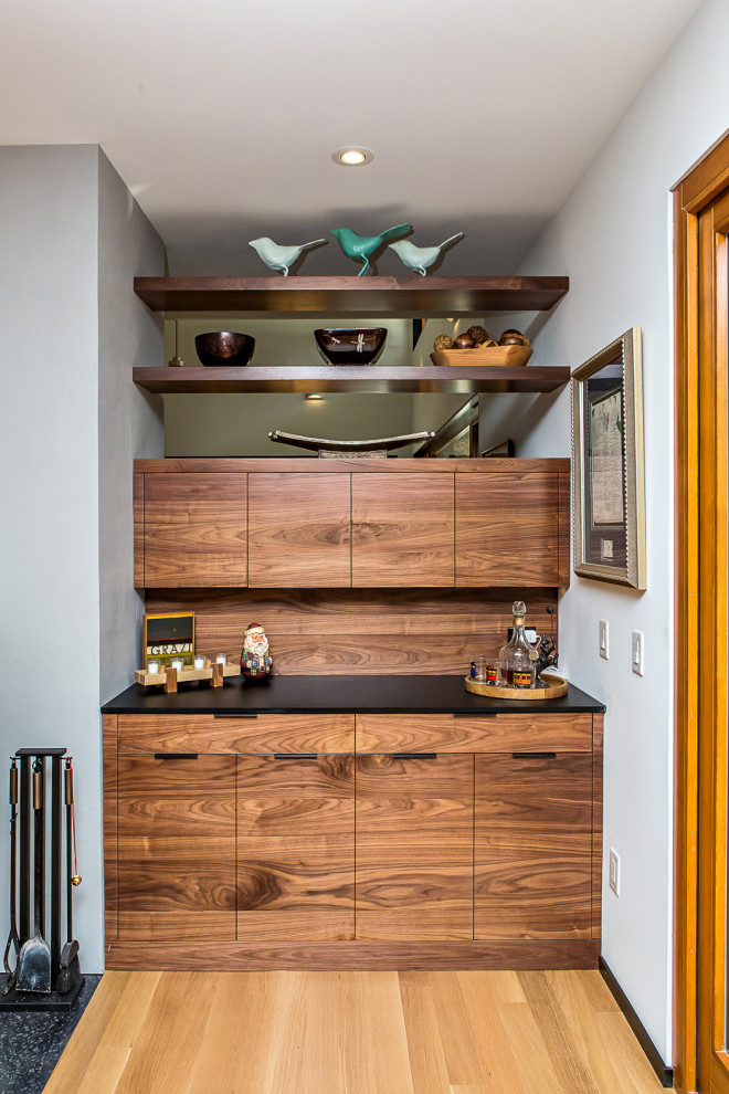 Imagen de comedor de cocina retro de tamaño medio con paredes azules, suelo de madera en tonos medios, chimenea de doble cara, marco de chimenea de yeso y suelo marrón