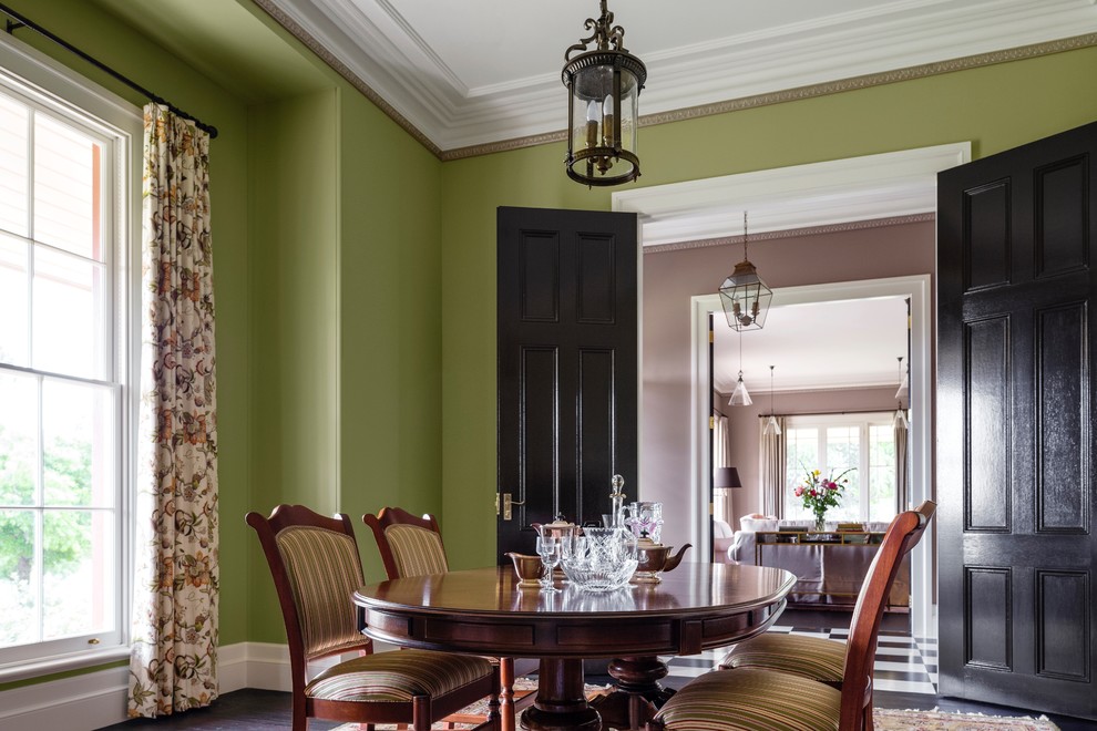 Aménagement d'une grande salle à manger campagne avec une cheminée standard, un manteau de cheminée en pierre, un mur vert et un sol en bois brun.