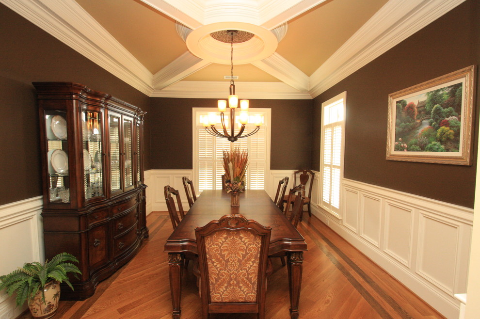 Example of a mid-sized classic medium tone wood floor and brown floor enclosed dining room design in Raleigh with brown walls