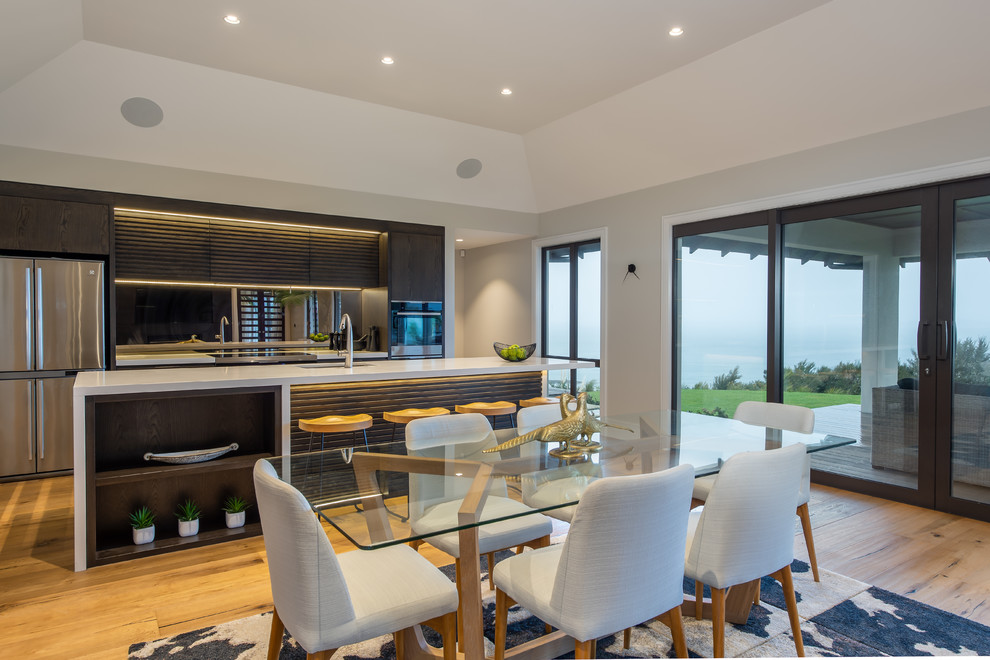 Große Moderne Wohnküche mit grauer Wandfarbe, braunem Holzboden und braunem Boden in Auckland