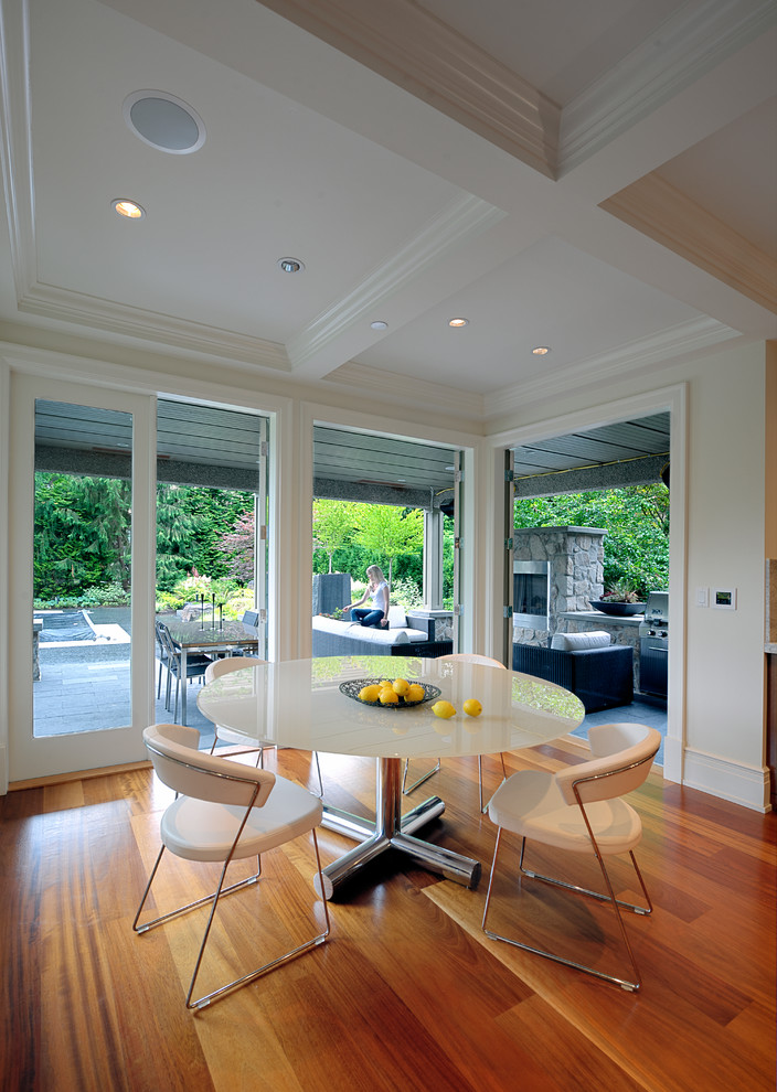 This is an example of a contemporary dining room in Vancouver with white walls and medium hardwood flooring.