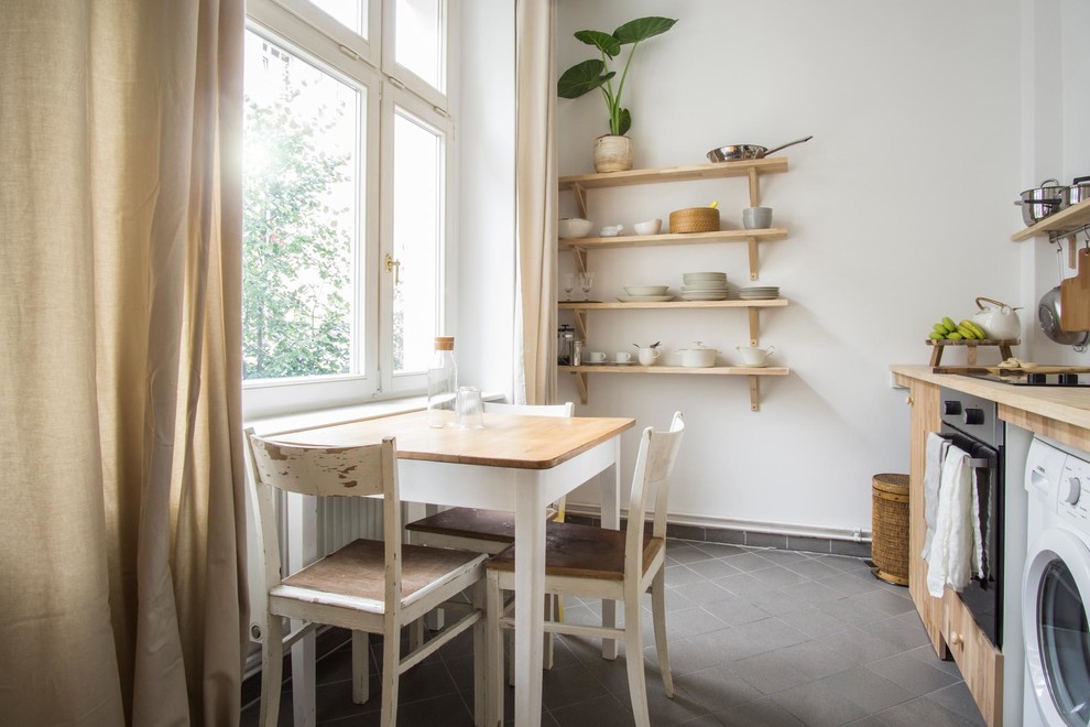 Modelo de comedor de cocina escandinavo pequeño sin chimenea con paredes blancas y suelo gris