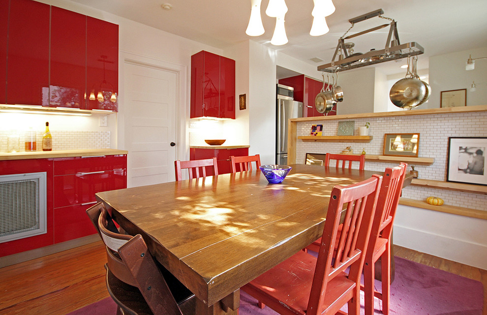 Immagine di una sala da pranzo aperta verso la cucina country di medie dimensioni con pareti bianche, pavimento in legno massello medio, nessun camino e pavimento marrone