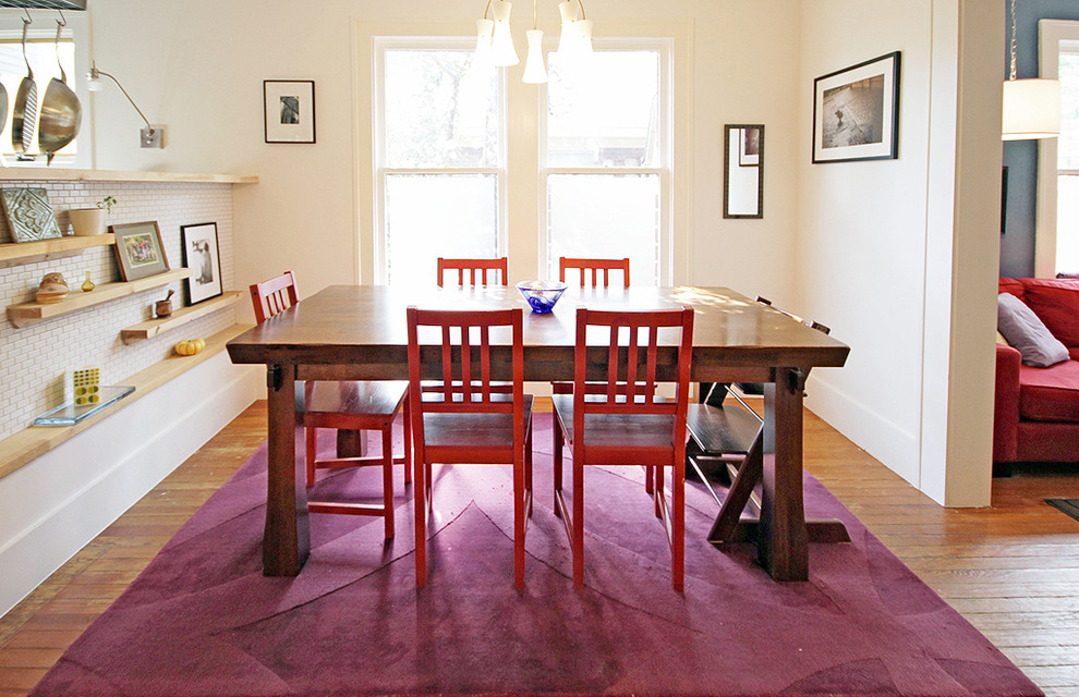 Cette image montre une salle à manger design avec un mur blanc et un sol en bois brun.