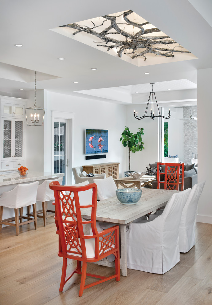 Inspiration for a nautical open plan dining room in Miami with white walls and light hardwood flooring.