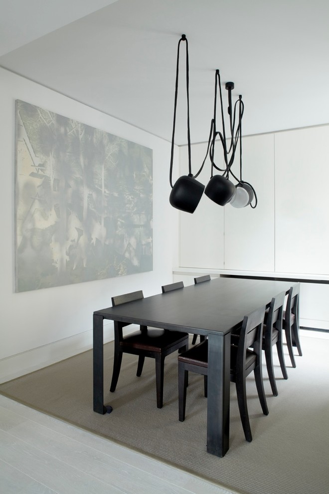 This is an example of a modern dining room in London with white walls.
