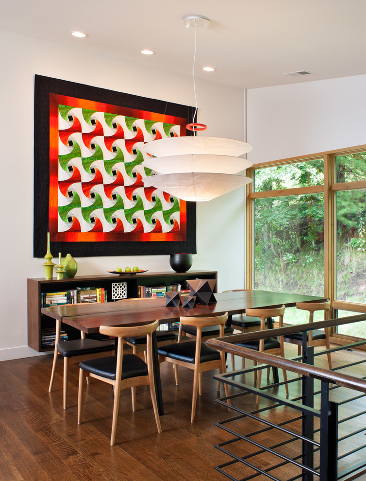 Esempio di una sala da pranzo aperta verso la cucina design di medie dimensioni con pareti bianche, parquet scuro e pavimento marrone