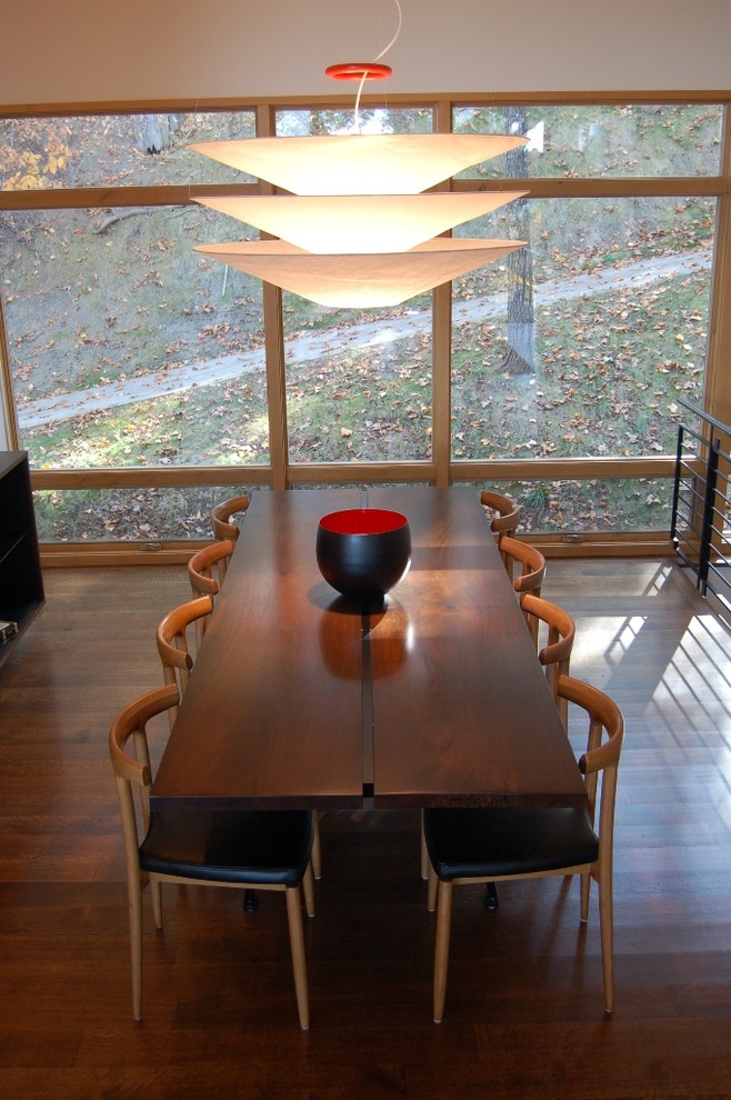 Immagine di una sala da pranzo aperta verso la cucina minimal di medie dimensioni con parquet scuro, pareti beige e pavimento marrone