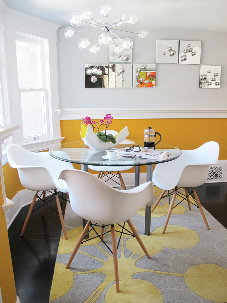 Réalisation d'une petite salle à manger minimaliste fermée avec un mur jaune, parquet foncé, aucune cheminée et un sol noir.