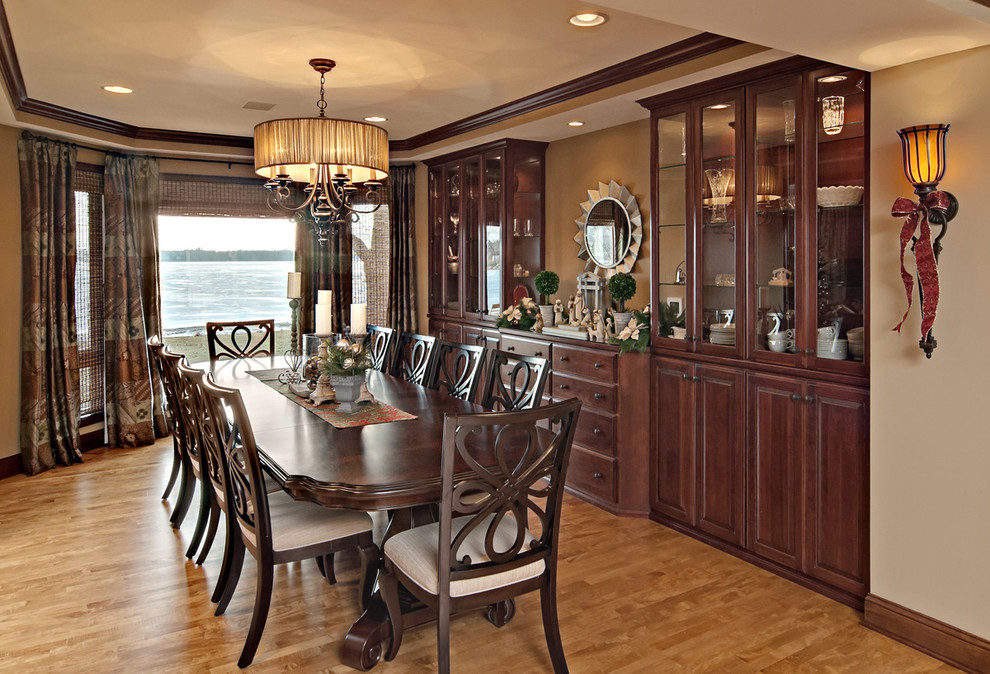 Diseño de comedor clásico con paredes beige, suelo de madera en tonos medios y cortinas