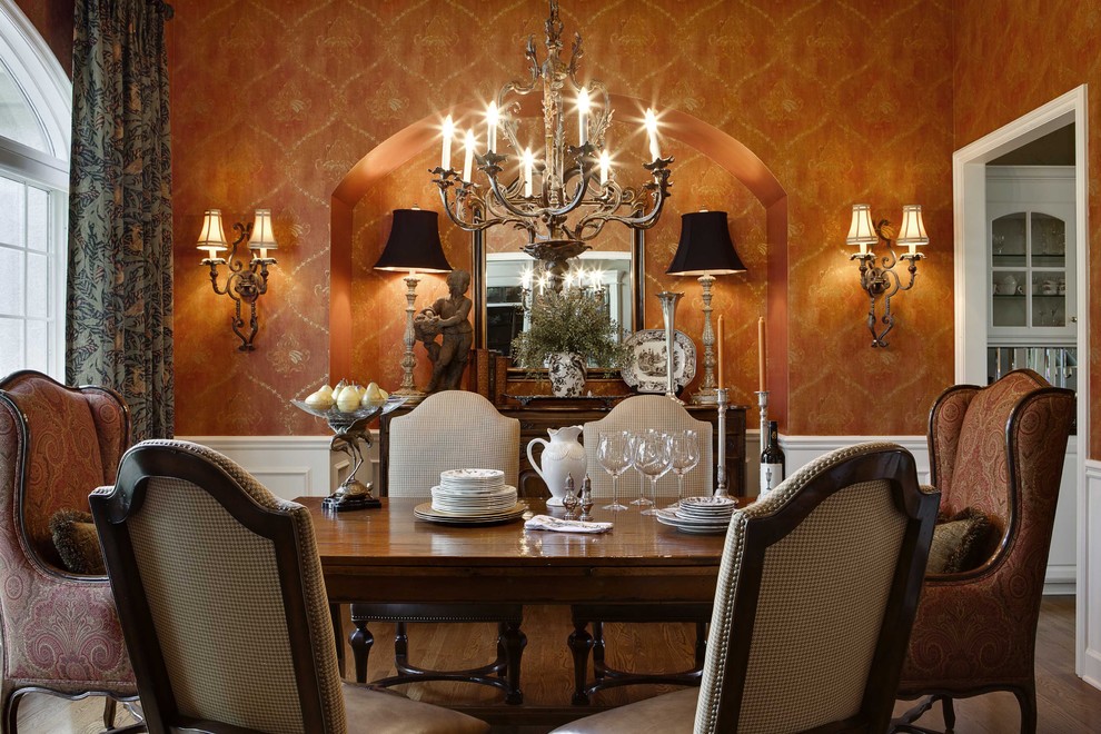 Imagen de comedor clásico cerrado con parades naranjas, suelo de madera en tonos medios y cortinas