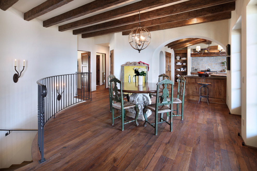This is an example of a large mediterranean kitchen/dining room in Orange County with white walls and dark hardwood flooring.