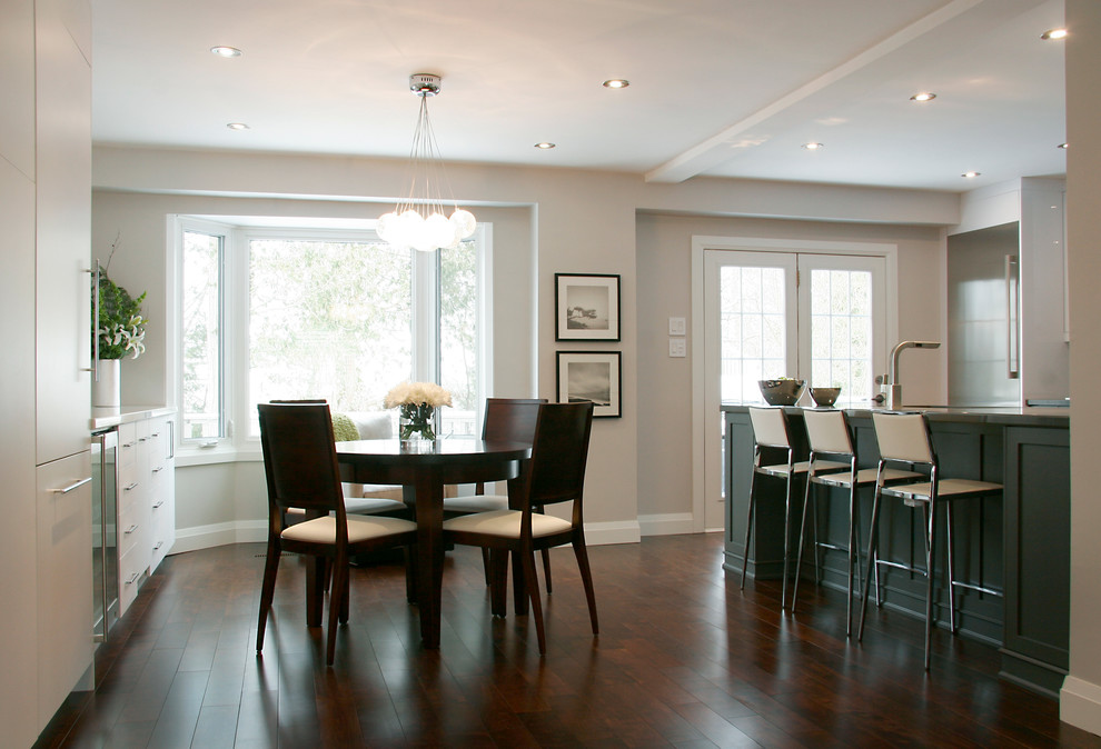 Foto di una piccola sala da pranzo aperta verso la cucina tradizionale con pareti beige, parquet scuro, camino classico e pavimento marrone