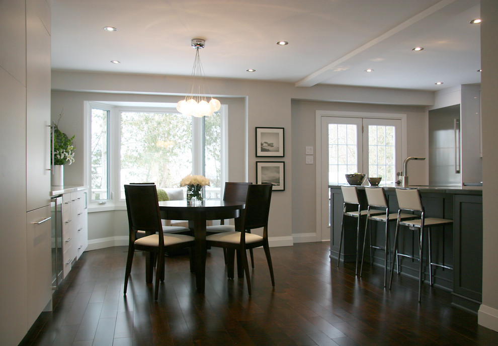 Idee per una piccola sala da pranzo aperta verso la cucina chic con pareti beige, parquet scuro, camino classico e pavimento marrone