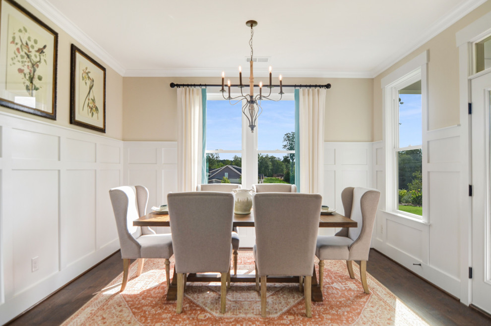 Foto di una grande sala da pranzo aperta verso la cucina country con pareti grigie, pavimento in legno massello medio, pavimento marrone e boiserie