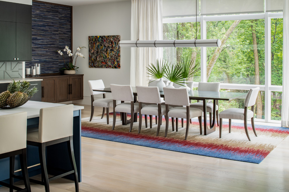 This is an example of a contemporary open plan dining room in DC Metro with white walls, light hardwood flooring, no fireplace and beige floors.