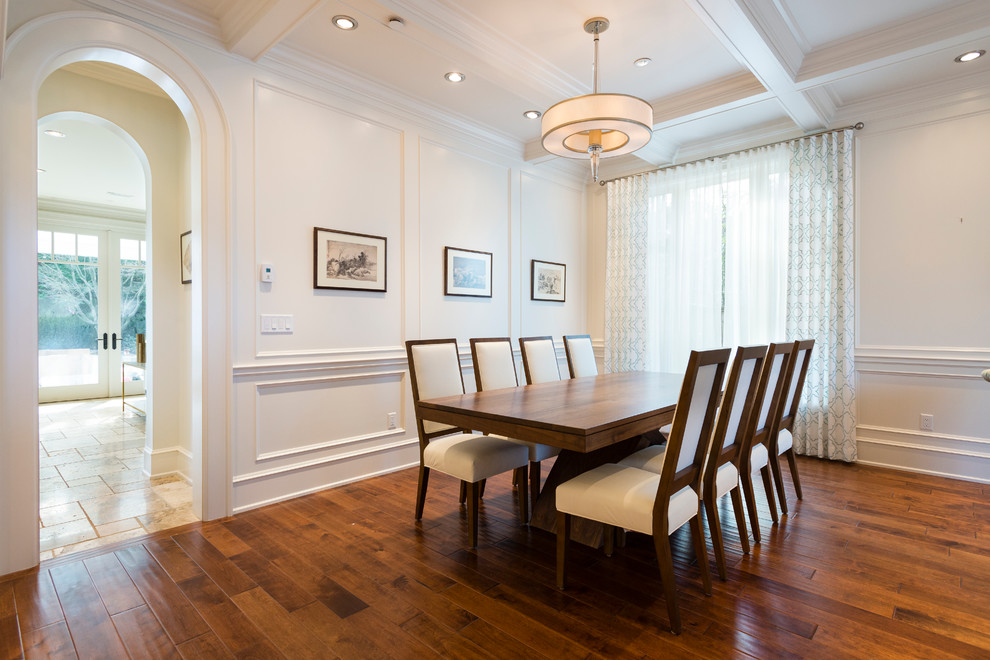 This is an example of a medium sized classic open plan dining room in Vancouver with white walls, medium hardwood flooring, a standard fireplace and a stone fireplace surround.