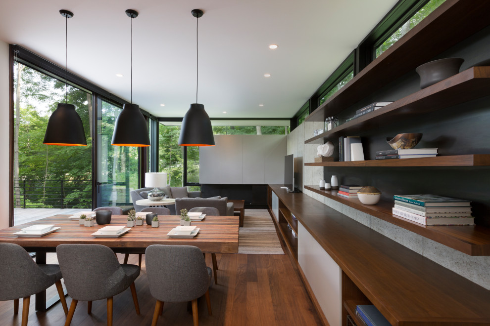 Diseño de comedor actual abierto con paredes grises, suelo de madera en tonos medios y suelo marrón