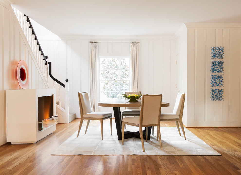 Photo of a medium sized traditional enclosed dining room in Dallas with white walls, medium hardwood flooring, a standard fireplace, a plastered fireplace surround and beige floors.