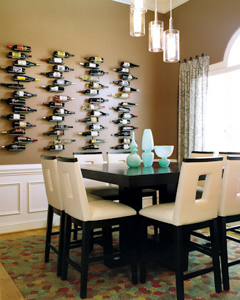 Immagine di una sala da pranzo aperta verso la cucina contemporanea di medie dimensioni con pareti marroni e parquet chiaro