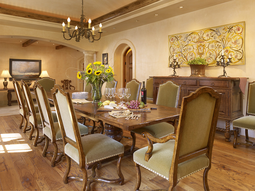 Cette image montre une salle à manger méditerranéenne avec un mur beige et un sol en bois brun.