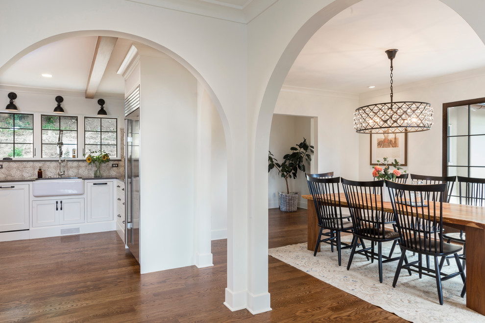 Photo of a medium sized mediterranean open plan dining room in Portland with white walls, dark hardwood flooring and brown floors.