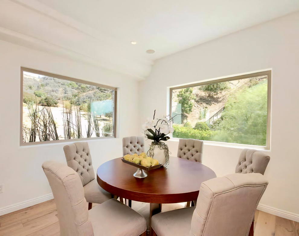 Breakfast nook - mid-sized mediterranean light wood floor and beige floor breakfast nook idea in Los Angeles with white walls and no fireplace
