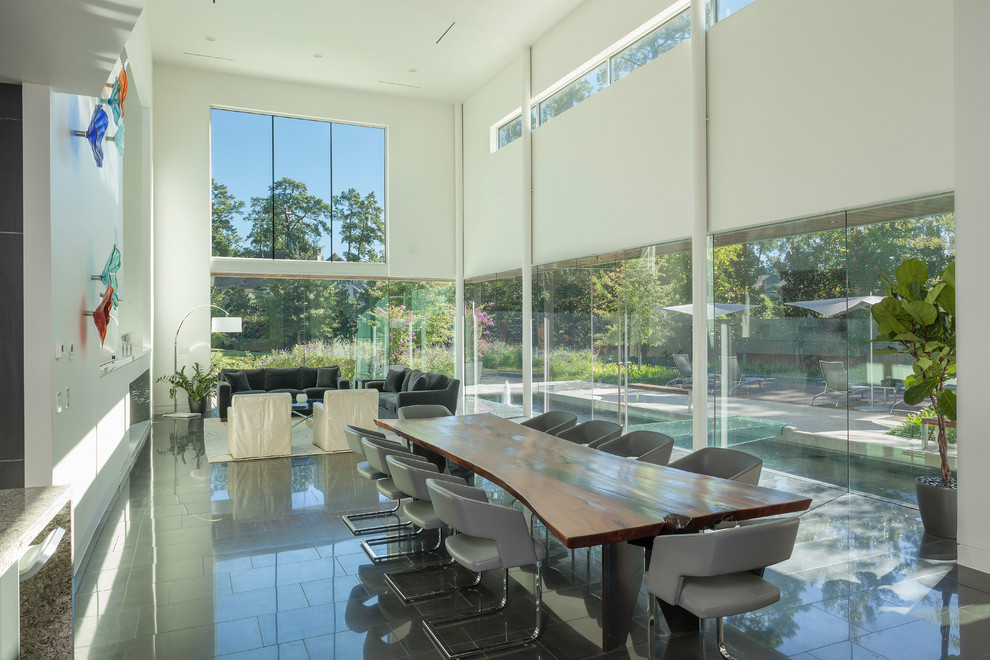 This is an example of a large modern dining room in Houston with white walls, ceramic flooring, a standard fireplace, a stone fireplace surround and feature lighting.
