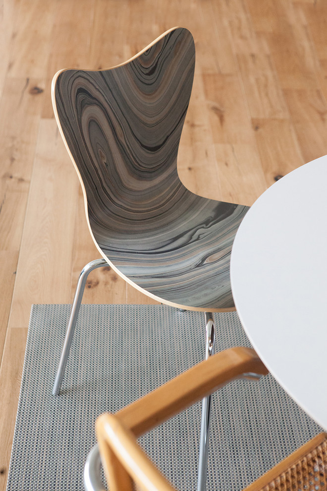 Foto di una sala da pranzo aperta verso la cucina minimalista di medie dimensioni con pareti bianche, pavimento in legno massello medio e pavimento marrone