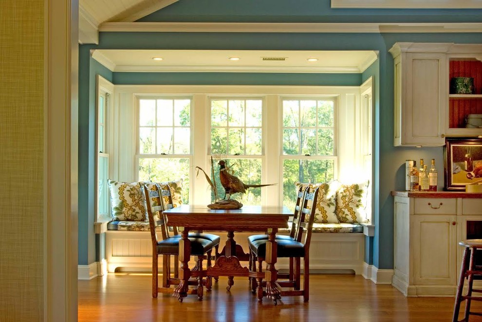 Example of a mid-sized country medium tone wood floor kitchen/dining room combo design in New York with blue walls