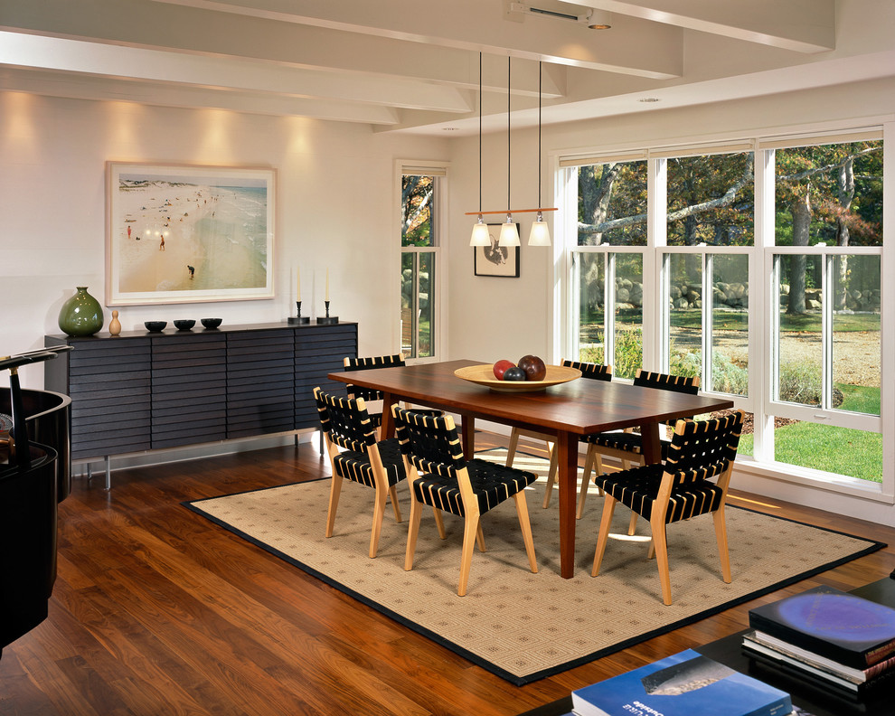 Inspiration for a beach style dining room in Boston with white walls, dark hardwood flooring and feature lighting.