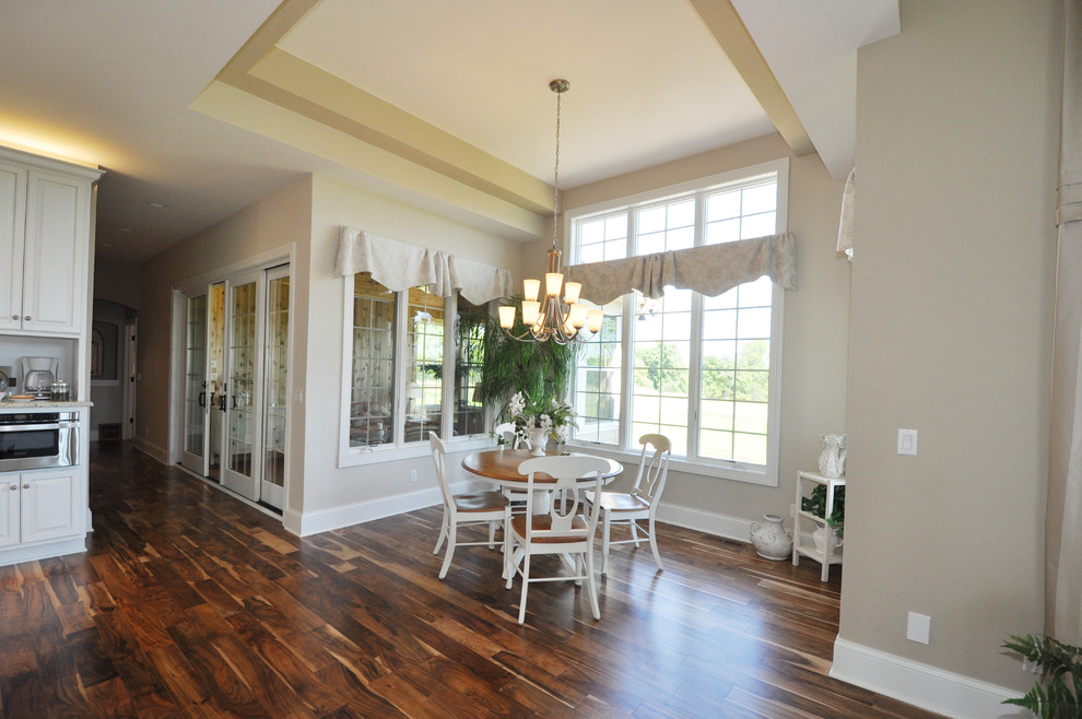 Ispirazione per una grande sala da pranzo aperta verso la cucina classica con pareti beige e pavimento in legno massello medio