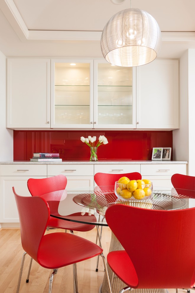 На фото: столовая в современном стиле с красными стенами и светлым паркетным полом