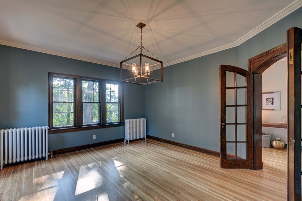 Elegant light wood floor enclosed dining room photo in Omaha with beige walls