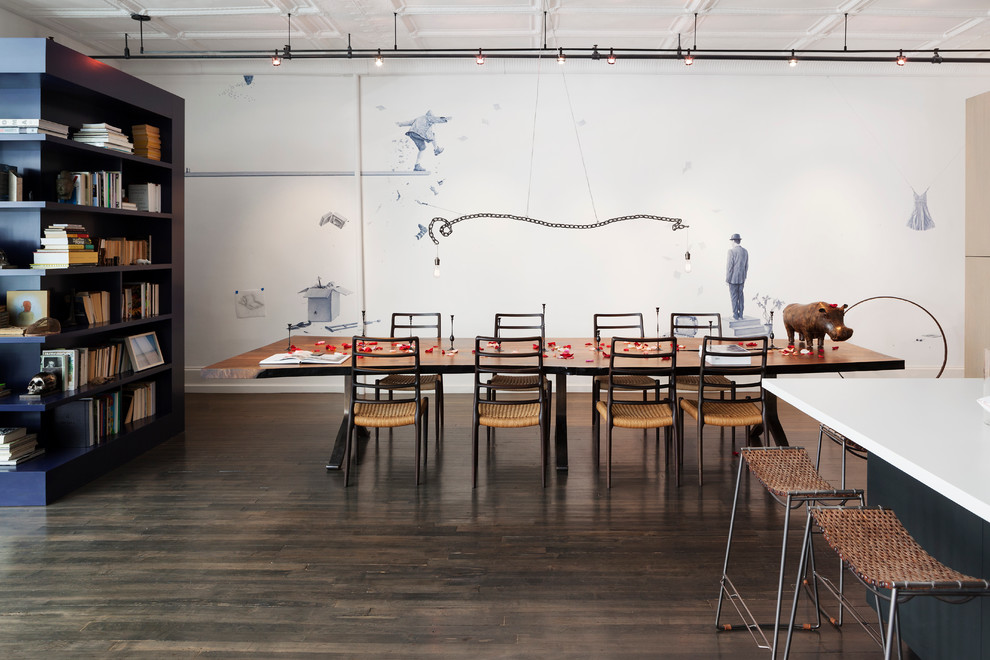 This is an example of an urban dining room in New York with white walls and dark hardwood flooring.