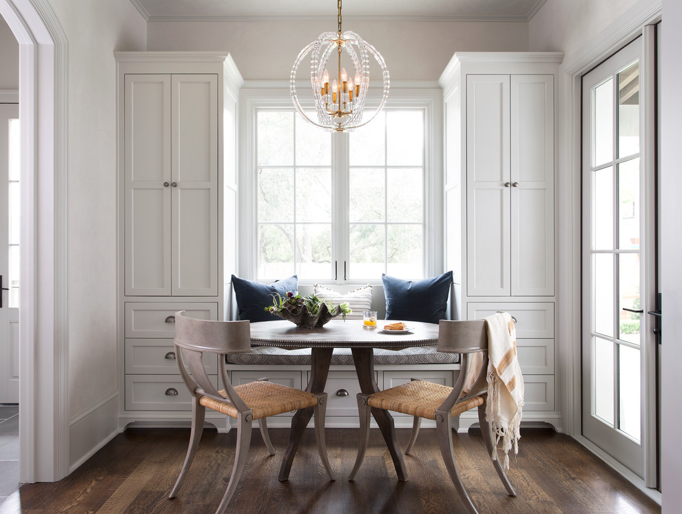 Example of a transitional dark wood floor enclosed dining room design in Austin with white walls