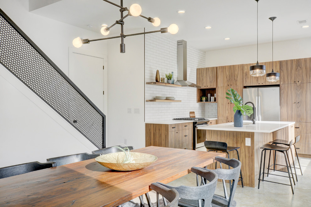 Exemple d'une salle à manger ouverte sur la cuisine industrielle avec un mur blanc, sol en béton ciré et un sol gris.