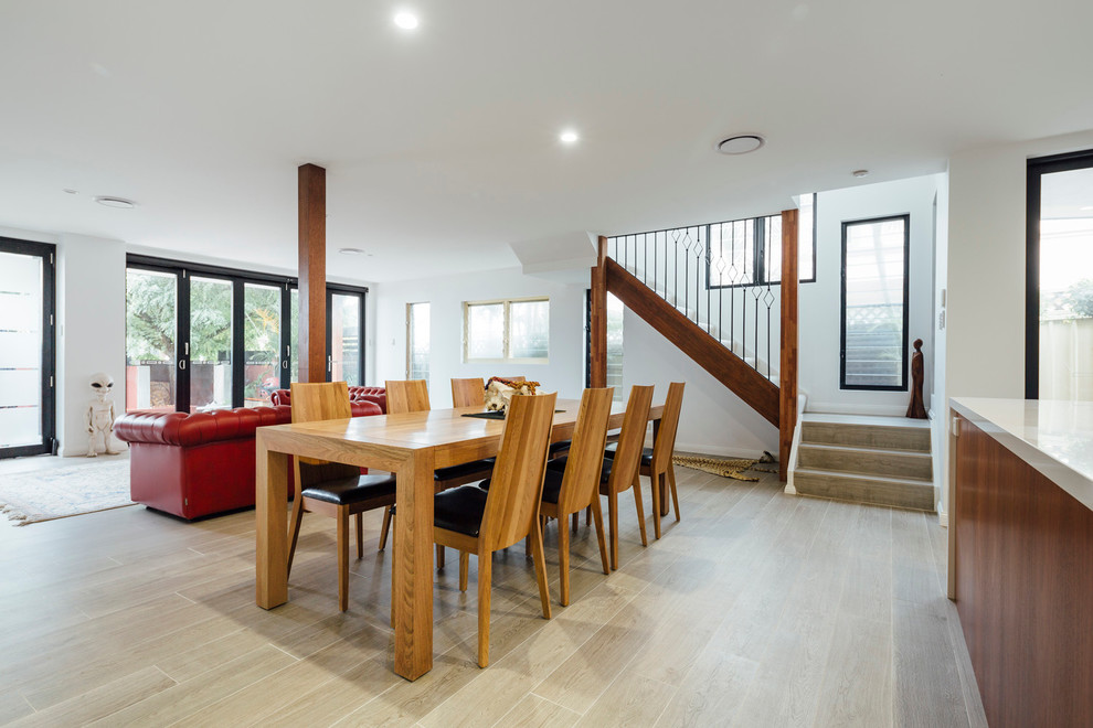 This is an example of a contemporary open plan dining room in Sydney with white walls and light hardwood flooring.