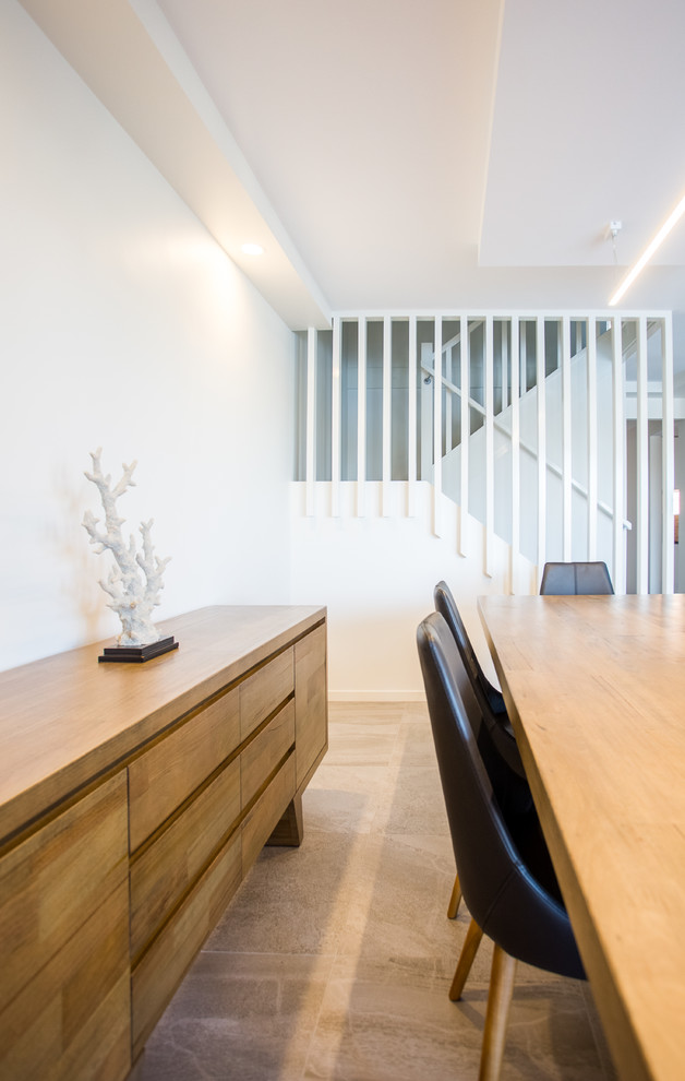 Esempio di una piccola sala da pranzo aperta verso il soggiorno minimalista con pareti bianche, pavimento con piastrelle in ceramica e pavimento grigio
