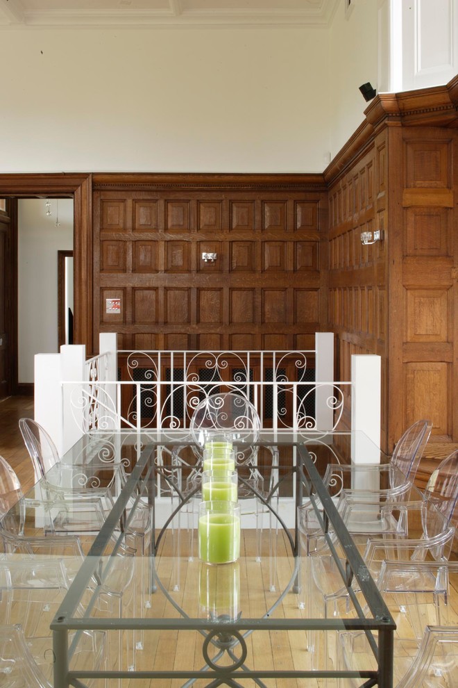 Idées déco pour une grande salle à manger ouverte sur le salon contemporaine avec un mur blanc, parquet clair et un manteau de cheminée en plâtre.