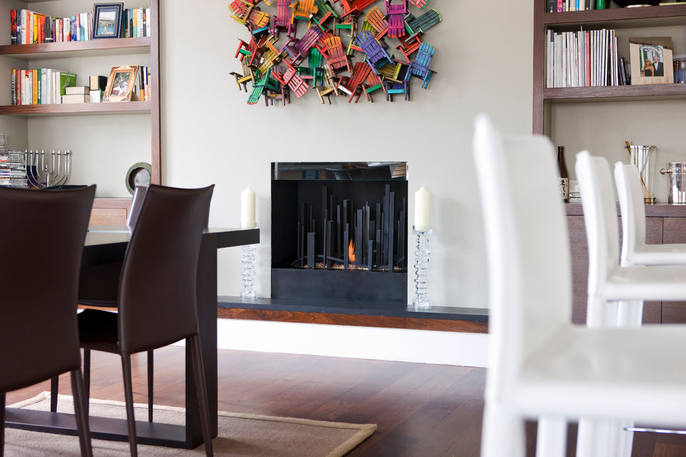 Idée de décoration pour une salle à manger design avec un manteau de cheminée en plâtre.