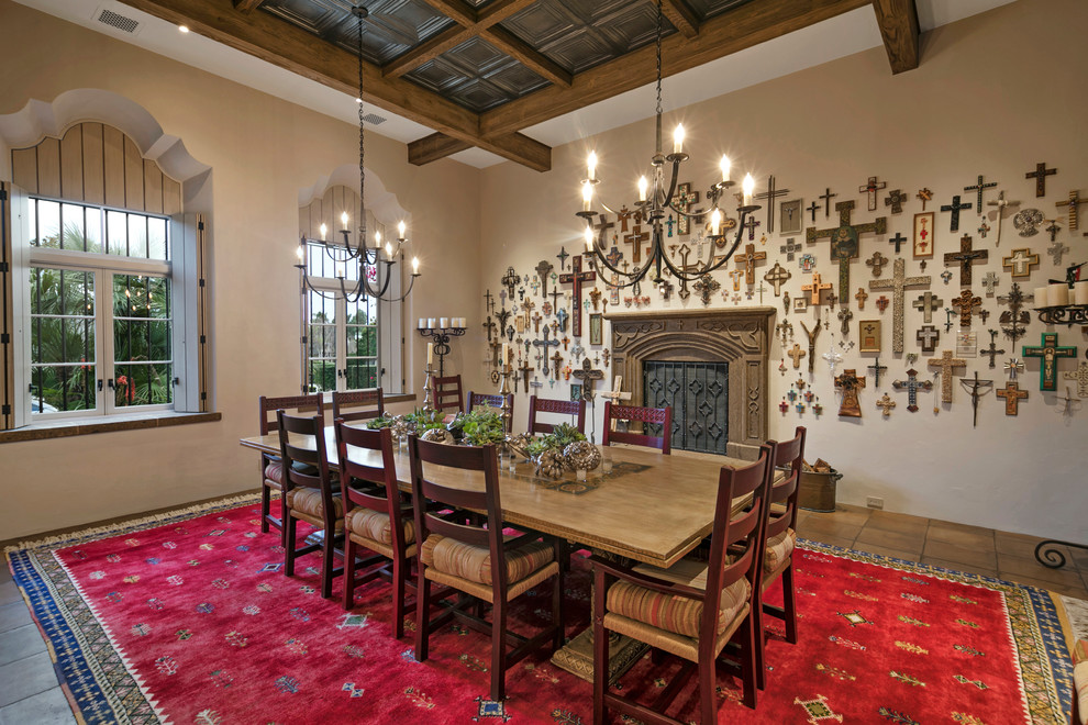 Example of a large tuscan terra-cotta tile enclosed dining room design in Santa Barbara with beige walls, a ribbon fireplace and a stone fireplace